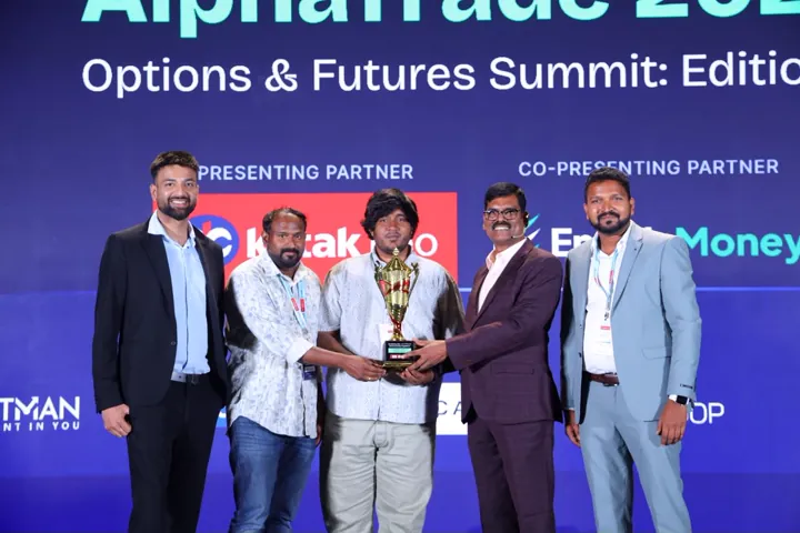A trophy presentation on the AlphaTrade 2025 stage